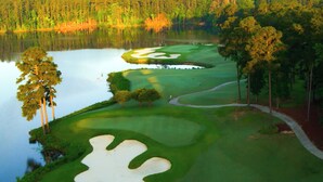 A golf course with sand bunkers, a pond, and surrounding trees. - Lakefront Mccormick Retreat w/ Patio & Views (McCormick)