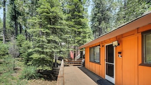 A cabin with a wooden exterior, a covered porch, and a door leading to the interior.