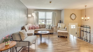 A spacious living room with a large sectional sofa, a round coffee table, and a staircase with a railing. - 5 Mi to Downtown Harrisburg - Family Home! (Harrisburg)
