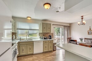 Una cocina moderna con una isla grande, armarios de madera y un comedor con mesa y sillas.