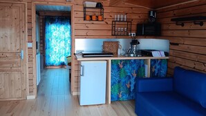 A wooden interior with a kitchenette, a small refrigerator, a blue sofa, and a patterned wall. - Unique stay on Jupiter, comfortable boat in Digoin (Digoin)