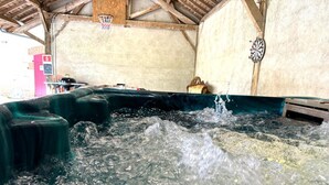 A hot tub with water splashing, a basketball hoop, and a dartboard on the wall. - Historic 1830 Mansion with Spa, Games, Pets Allowed (Jaligny-sur-Besbre)