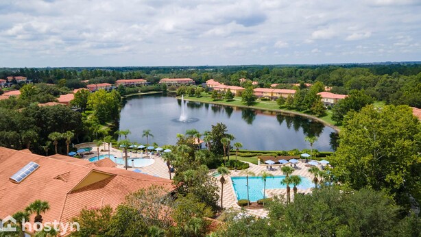Un resort con un lago extenso, una piscina y una fuente.