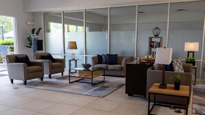 Una sala de estar moderna con un sofá, sillones, una mesa de centro y una estantería.