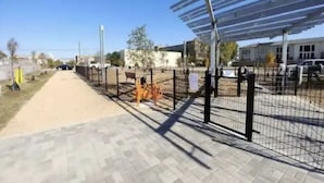 A paved walkway with a metal fence and a covered area with a roof. - HTX Ultra Hotel Suite #2 (Houston)