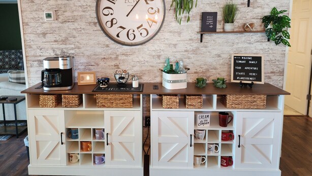 Una estación de café con un reloj, estantes con plantas y un cartel de bienvenida.