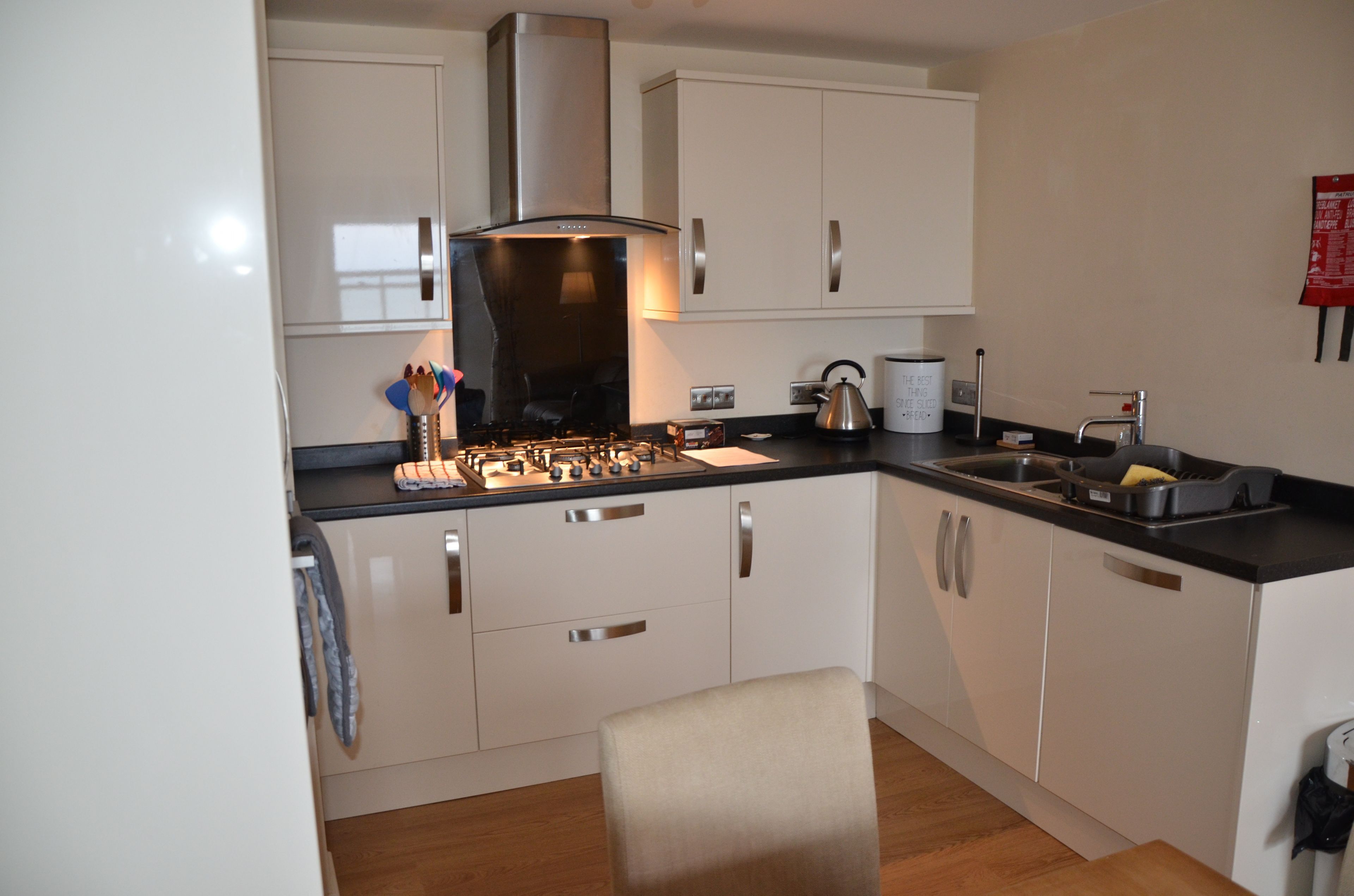 A modern kitchen with white cabinets, stainless steel appliances, and a black countertop.
