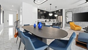 Una cocina moderna con armarios oscuros, una isla central e iluminación colgante.