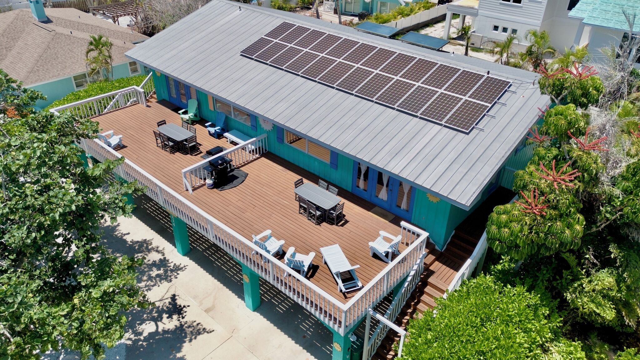 A two-story building with a deck and solar panels on the roof.