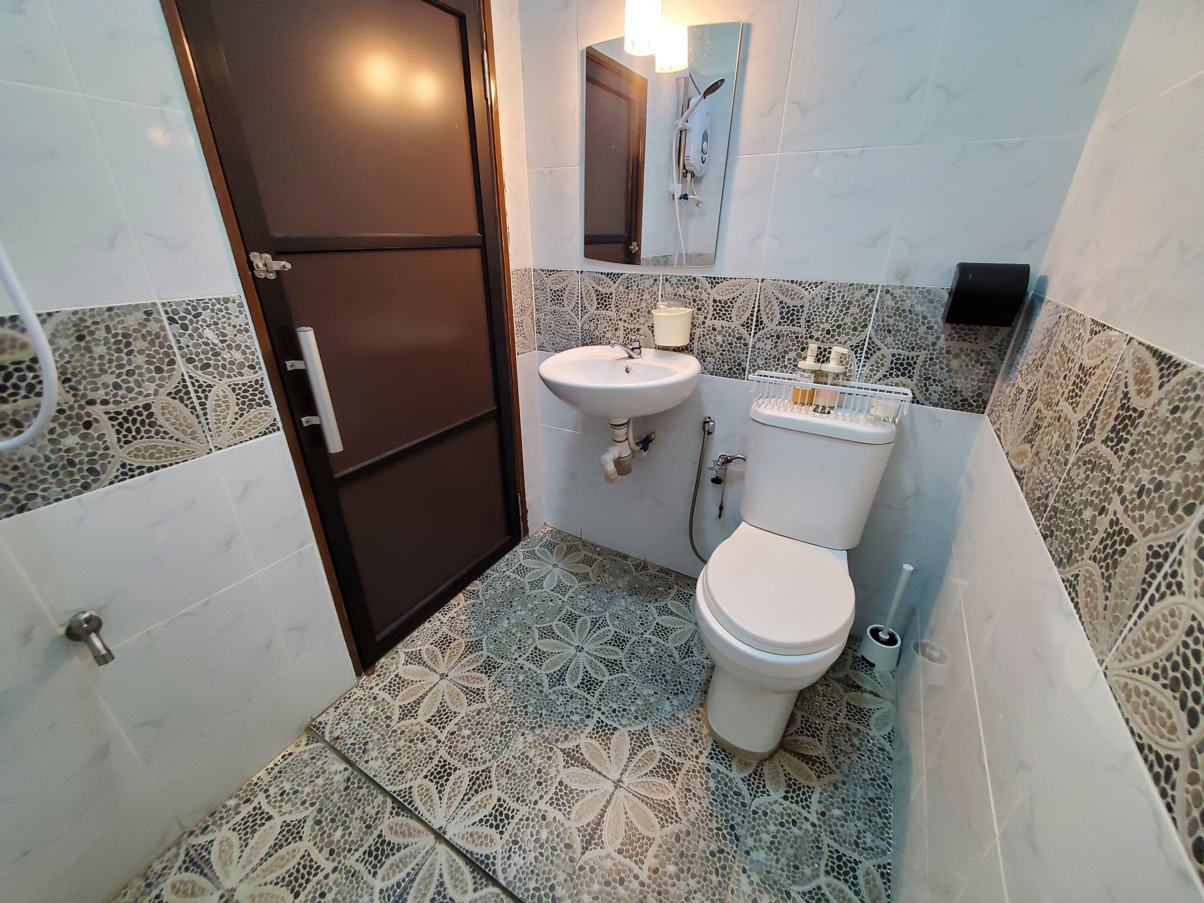 A bathroom with a toilet, sink, and shower area.
