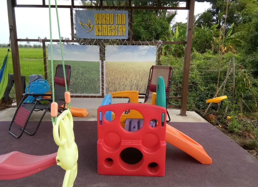 A playground with a swing set, a slide, and a climbing structure.