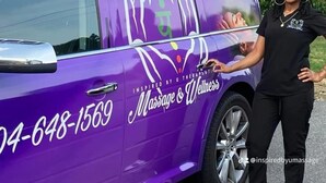 Ein lilafarbener Van mit der Aufschrift "Massage & Wellness" und einer Telefonnummer.