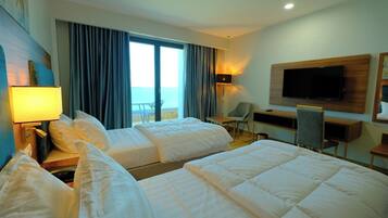 A hotel room with two beds, a TV mounted on the wall, a desk, and a chair.