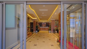 A hotel lobby with a star-patterned floor, a reception desk, and a glass elevator. - Hotel El Bey Jijel  (Jijel)