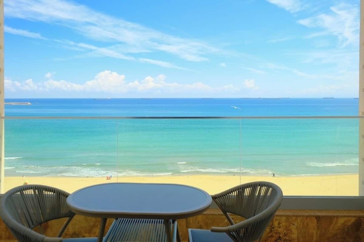 Un balcón con vista a la playa y al océano.
