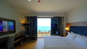 A hotel room with a bed, a desk, a television, and a balcony with a view of the sea. - Hotel El Bey Jijel  (Jijel)