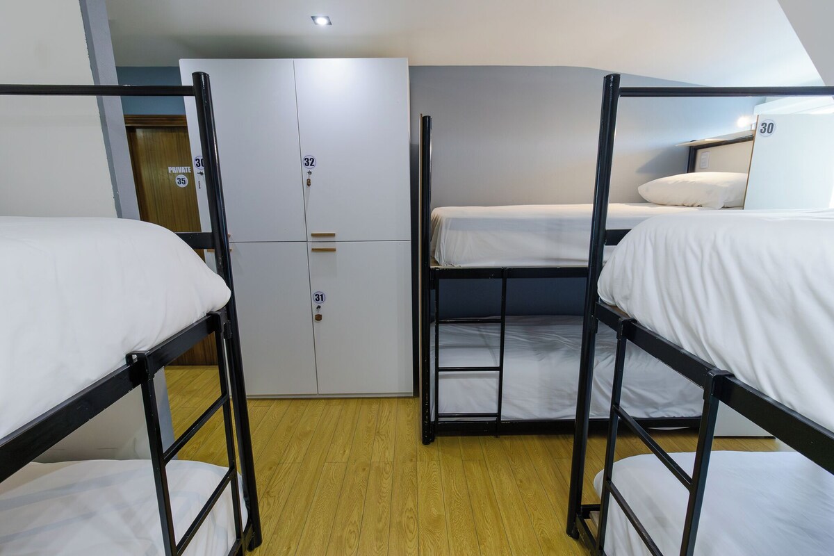 Habitación tipo dormitorio con literas, armario y puerta privada.