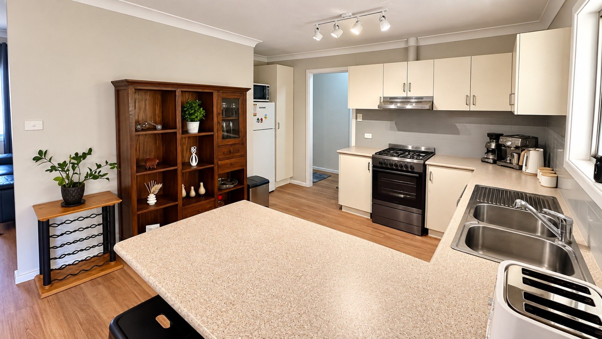 A modern kitchen with a central island, stainless steel appliances, and wooden cabinetry.