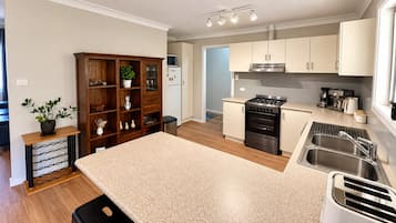 A modern kitchen with a central island, stainless steel appliances, and wooden cabinetry.