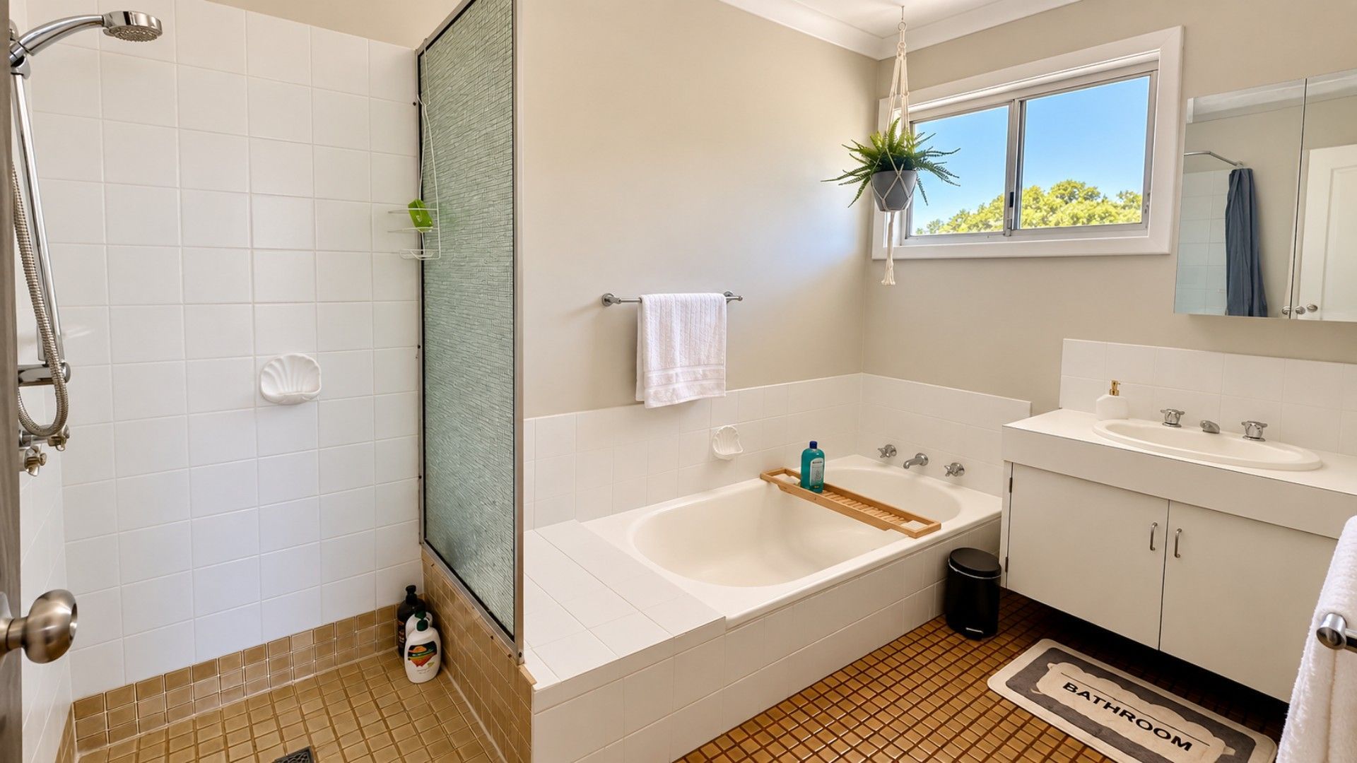 A bathroom with a shower, a bathtub, a sink, and a window with a view.