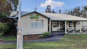 Un edificio identificado como 'Hannup Bowling Club' con un acceso cubierto y un pequeño espacio de estar al aire libre.