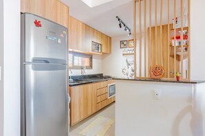 Enjoy cooking in this well-equipped kitchen with a refrigerator, oven, and wooden countertop.