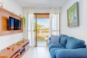 Relax in this stylish living room with a large sofa, flat-screen TV, and a console table, plus a balcony with a view.