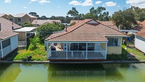 A row of beachside cottages with a small dock and a calm lake in the foreground. - Escape to Tranquility at Fountain View Villa - South Yunderup (South Yunderup)