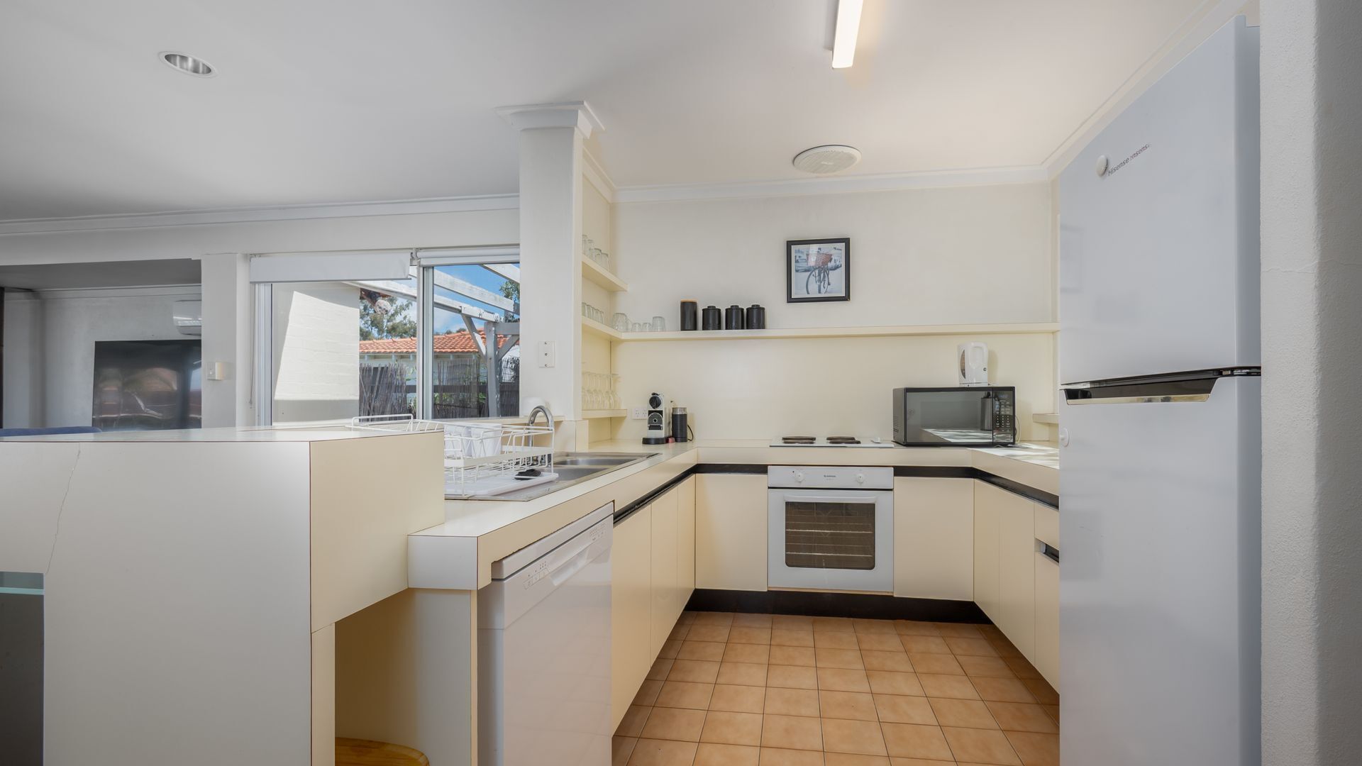 Een magnetron, een vaatwasser, een kinderstoel, eettafels