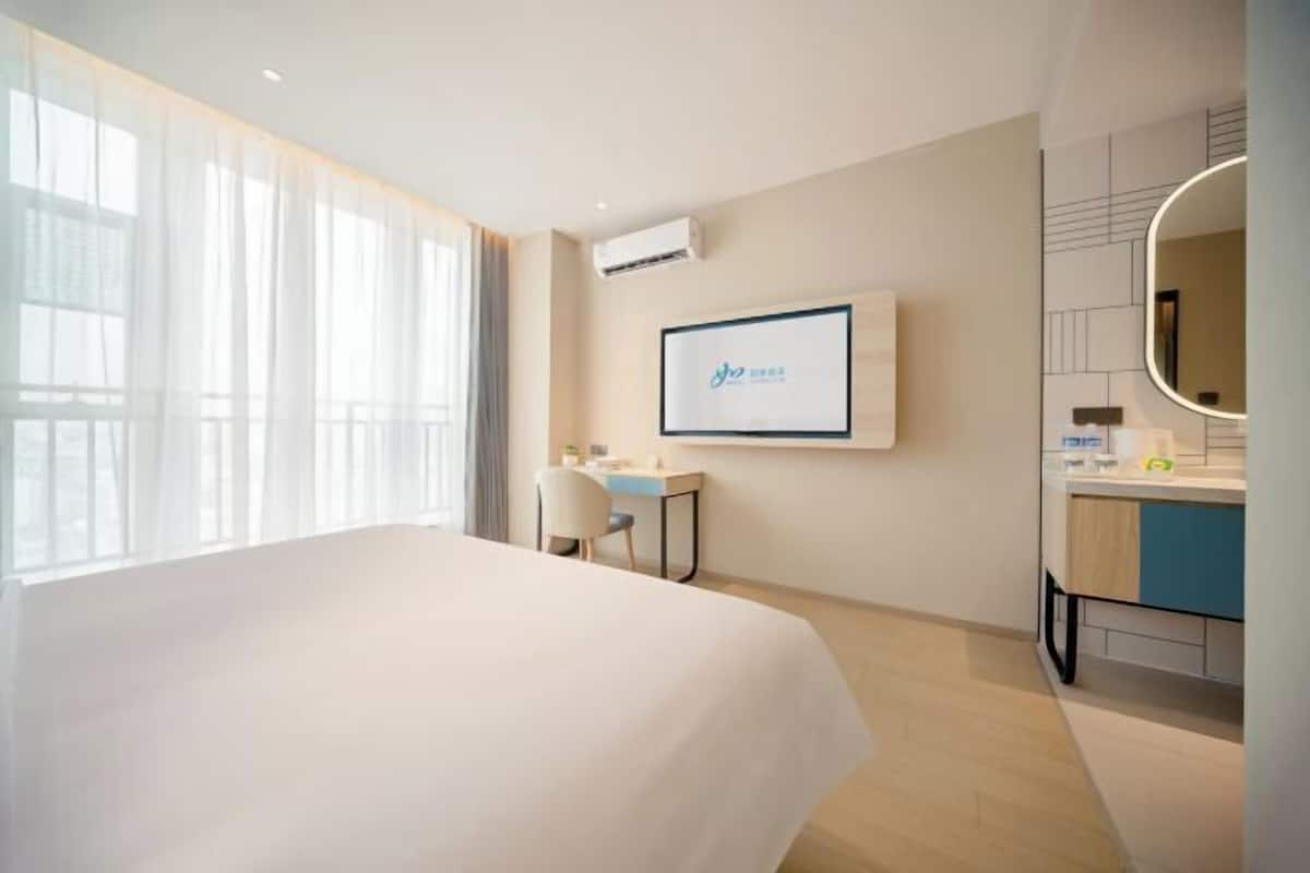 Une chambre d’hôtel avec un lit, un bureau et une salle de bain.
