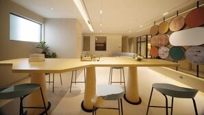 A modern dining area with a long table, four chairs, and a wall with decorative plates. - Homeinn · neo (Meishandong Railway Station Sansu Temple) (Meishan)