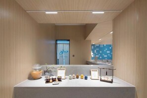 Un espace d’accueil avec un comptoir, des objets décoratifs encadrés et une porte visible au fond.