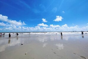 A beach with people walking on the sand and the ocean in the background. - Beihai Hyatt Hotel (high-speed railway station store) (Beihai)
