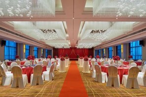 A banquet hall with round tables, a central aisle, and a red carpet. - Beihai Hyatt Hotel (high-speed railway station store) (Beihai)