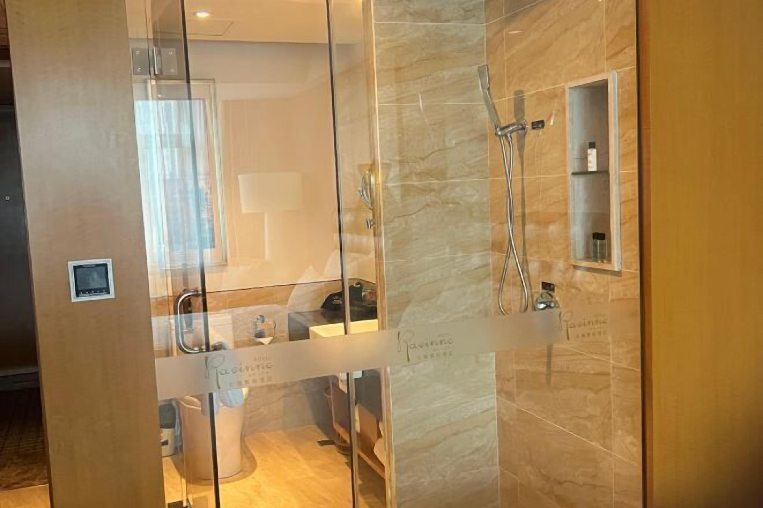A modern bathroom with a glass partition, a shower area, and a vanity with a mirror.