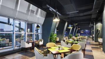A modern restaurant with high ceilings, large windows, and a checkered floor.