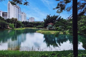 A calm lake surrounded by greenery and buildings in the background. - Beihai Hyatt Hotel (high-speed railway station store) (Beihai)