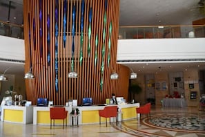 A hotel lobby with a reception desk, multiple chairs, and a decorative vertical panel. - Beihai Hyatt Hotel (high-speed railway station store) (Beihai)
