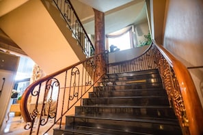 Stunning staircase with ornate railings and polished handrail, showcasing the property's attention to detail.