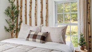 A bedroom with a bed, a window with curtains, a plant, and a wall with vertical wooden slats. - Charming Farmhouse, Sauna - 4 bedrooms, WiFi, AC in Upper Jay (Upper Jay)