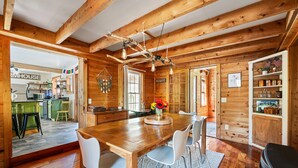 A wooden cabin interior with a dining area, kitchen, and living spaces. - Charming Farmhouse, Sauna - 4 bedrooms, WiFi, AC in Upper Jay (Upper Jay)