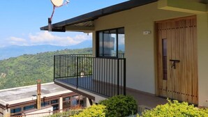 A modern building with a balcony, a satellite dish, and a view of green hills. - Hotel Casa Portones  (San Bernardo)