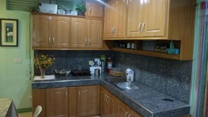 Una cocina con armarios de madera, encimera de granito y un lavabo.
