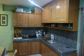 Cocina con armarios de madera, encimeras de granito y un fregadero.