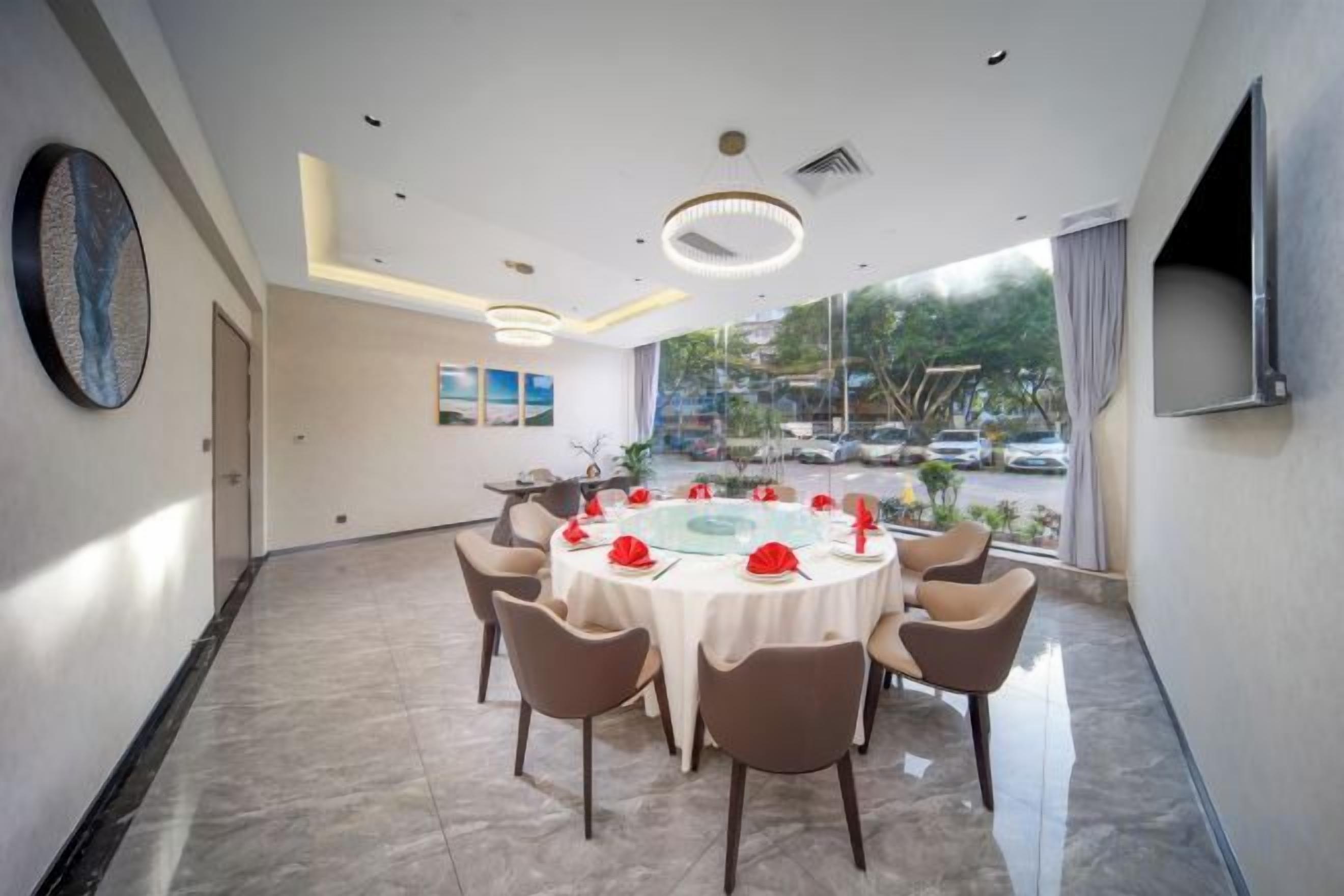 A conference room with a round table, chairs, and a TV screen.