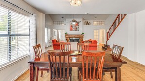 A dining area with a wooden table and chairs, a fireplace, and a staircase. - Spacious San Antonio Home: Google Fiber, Game Room (San Antonio)