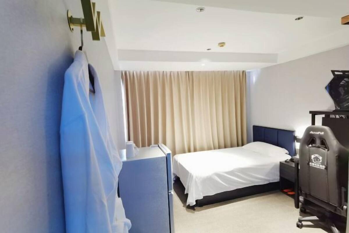 Una camera d'albergo con un letto, una scrivania, una sedia e un tavolino.
