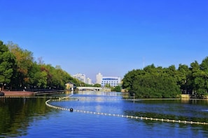 A calm lake with a bridge, surrounded by trees and buildings in the background. - Las Gaming Hotel (Ruian Wansong Branch) (Rui'an)