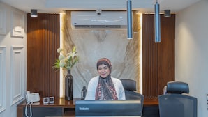 A reception desk with a nameplate, a phone, and a vase with flowers. - Gaia Pyramids View INN (Giza)