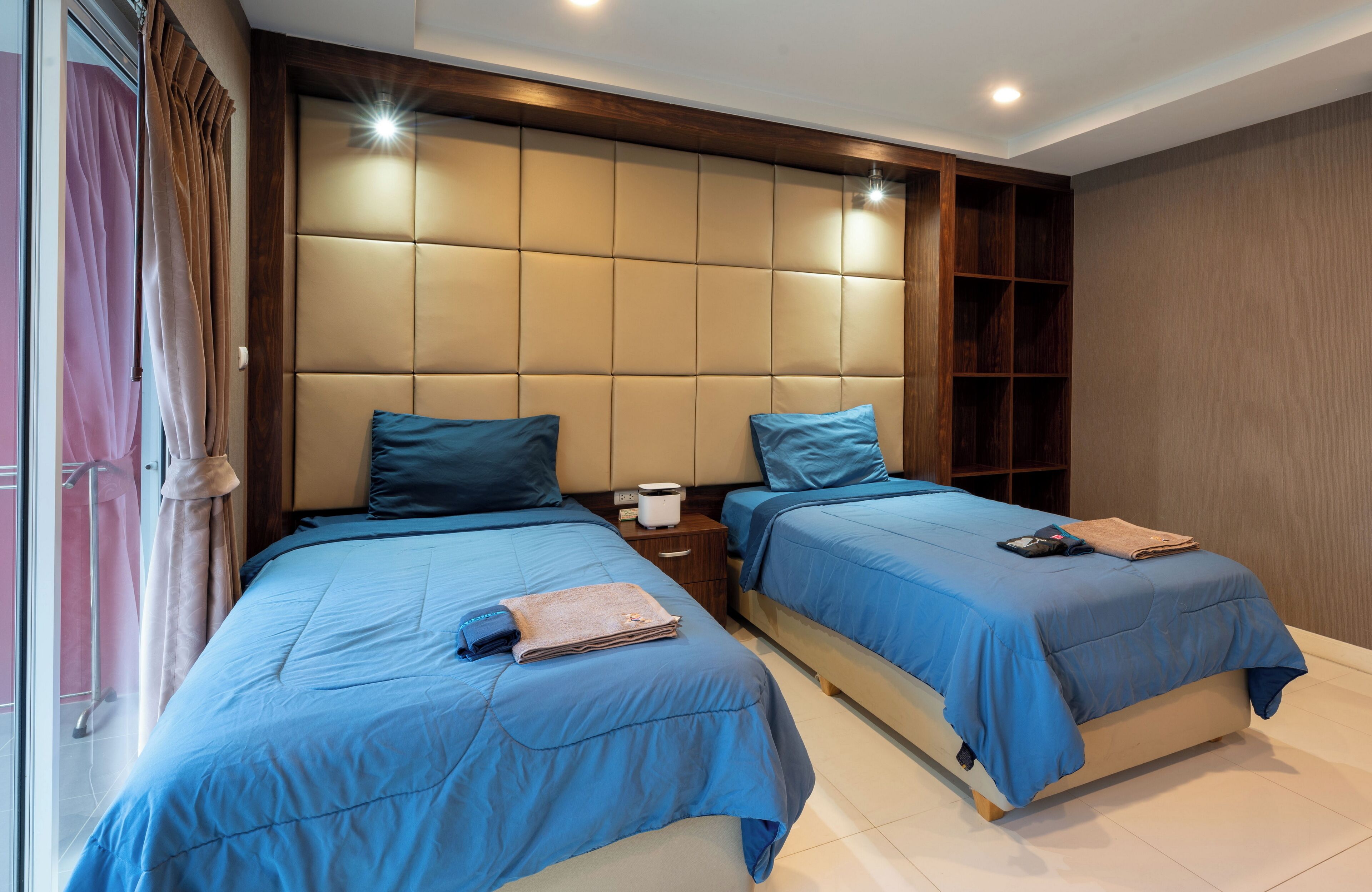 Una camera da letto con due letti, un comodino e una libreria a muro.